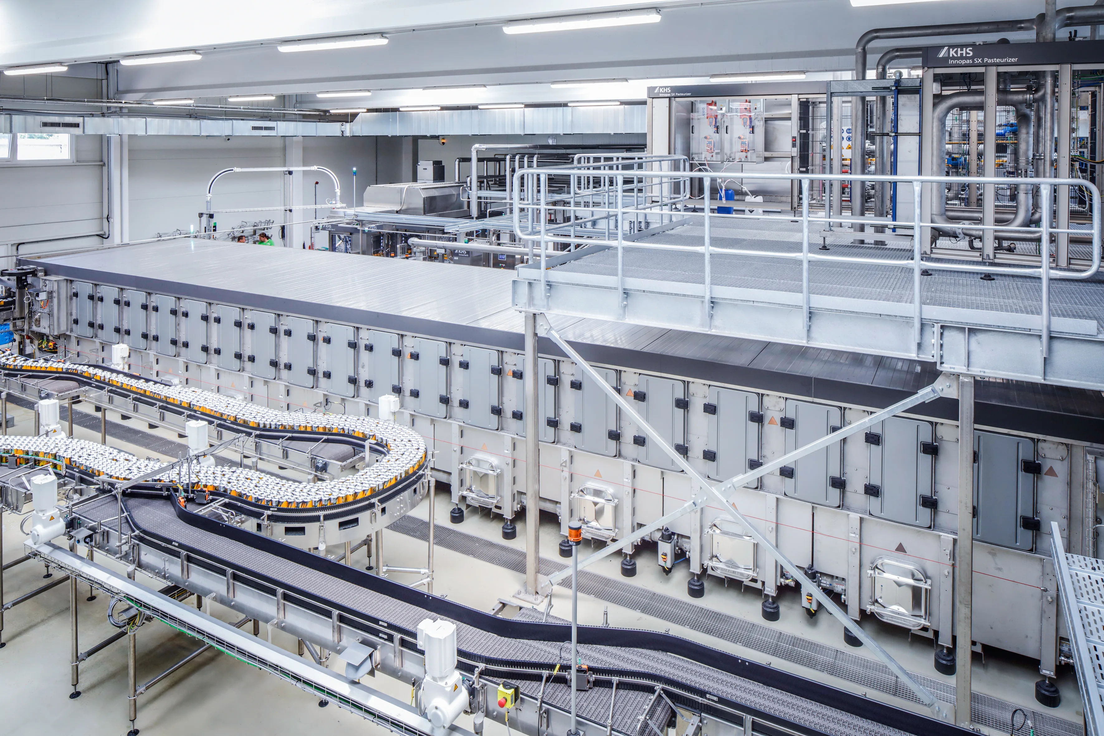 Vista de una nave de producción con el pasteurizador de túnel KHS Innopas SX.