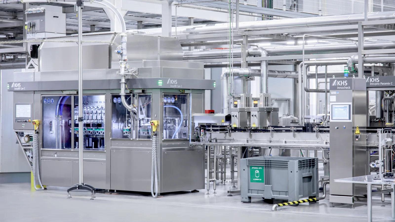Una máquina de llenado de bebidas con unidad de inspección en una sala de producción.