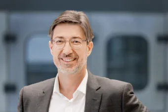 Tobias Wetzel, Director Ejecutivo de Ventas y Servicio en KHS, sonríe amablemente a la cámara.