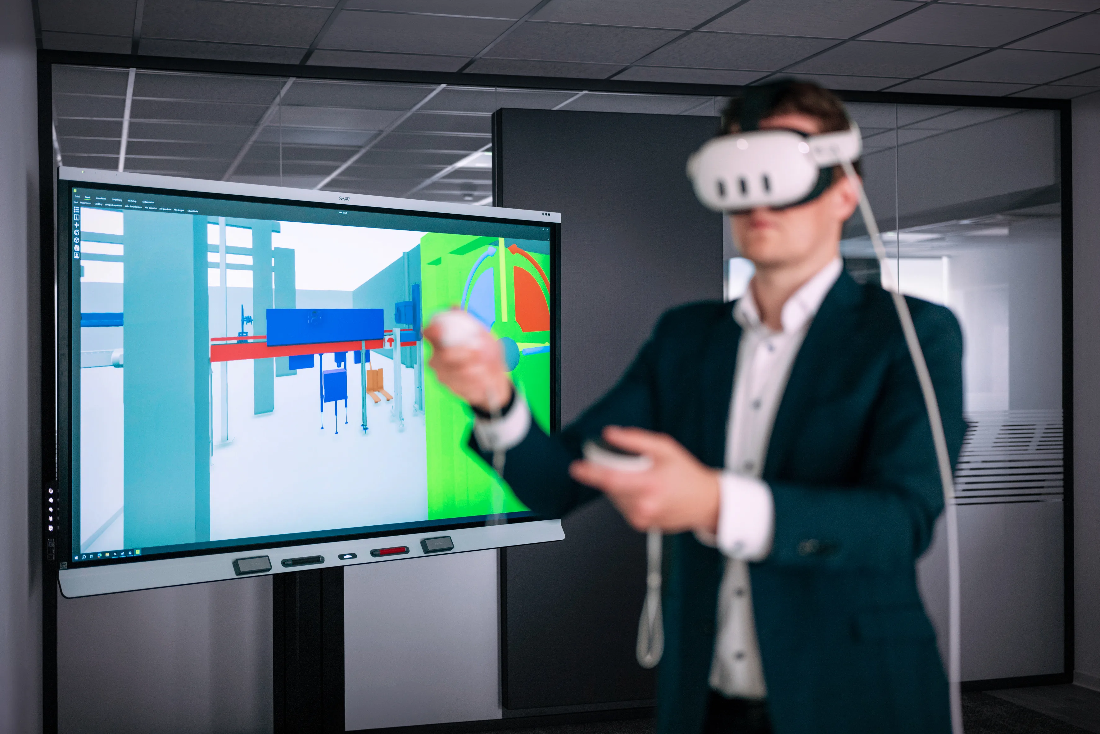 Una persona lleva puesto un visor de realidad virtual y está frente a una gran pantalla que muestra contenidos digitales.