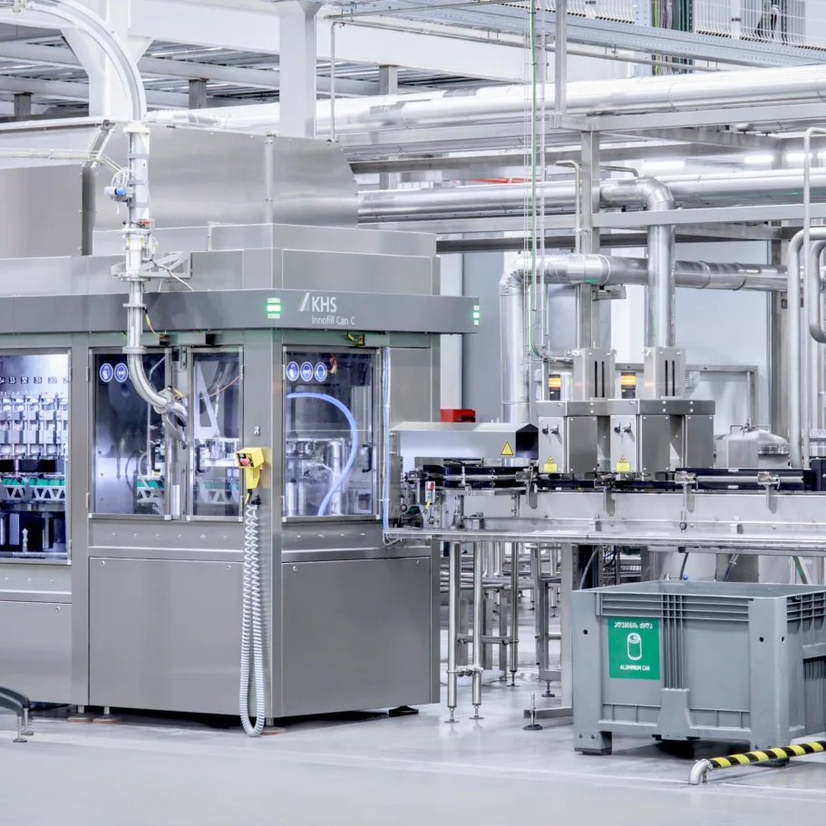 Una máquina de llenado de bebidas con unidad de inspección en una sala de producción.