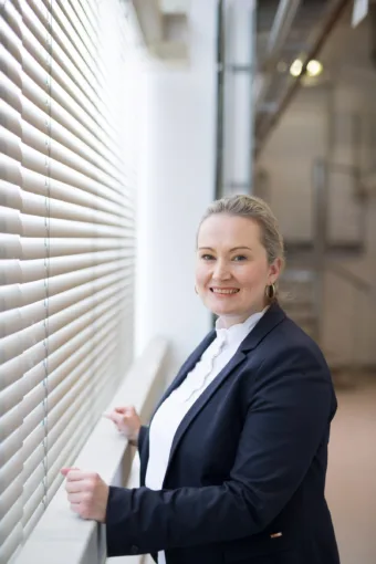 a woman leans against a window