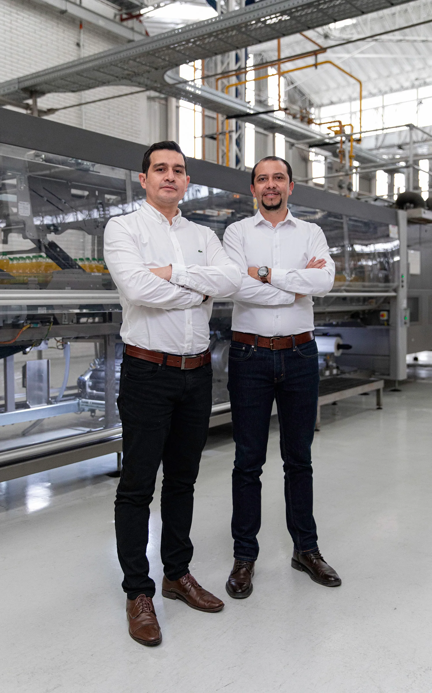 Dos hombres están parados en el vestíbulo de una fábrica.