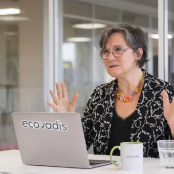 eine Frau sitzt an einem Tisch vor einem Laptop