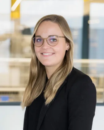 eine Frau, die eine Brille trägt und lächelt